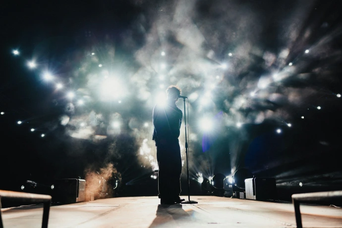 Performer on stage with bright lights and smoke
